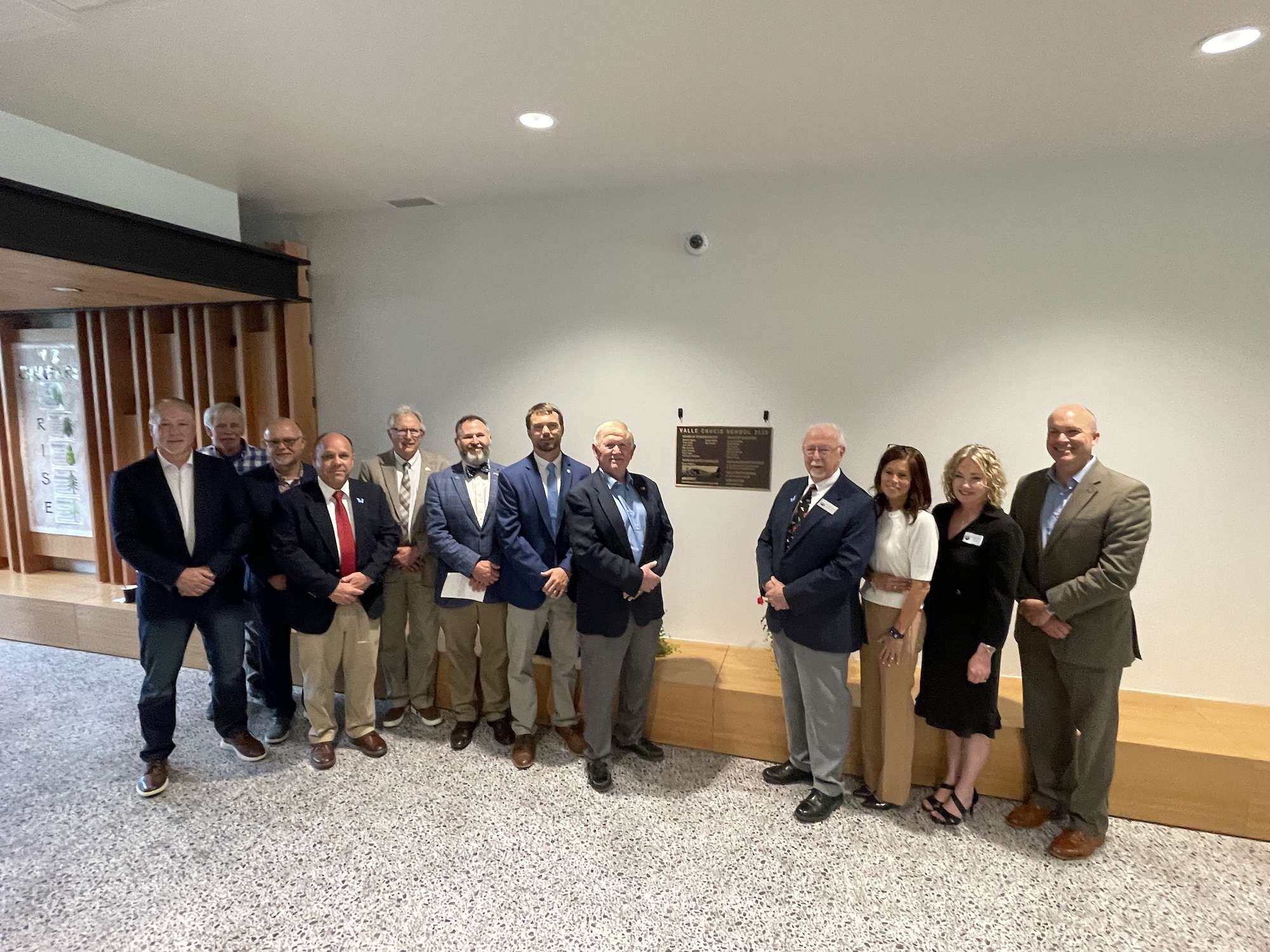 Officials gather inside Valle Crucis School near the dedication plaque following the ceremony.