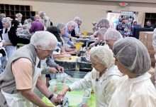 Volunteers in hairnets pack meals at long tables at First Baptist Church of Newland during the Hope for the High Country event on June 20, 2026, benefiting Avery County families recovering from Hurricane Helene.