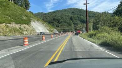 Traffic on N.C. 105 approaching the Broadstone Road intersection, with new pavement under construction alongside the open lane.