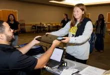 An E2D representative hands a new laptop to a first-year App State student during the Aug. 27 distribution event in Plemmons Student Union. Photo by Kyla Willoughby