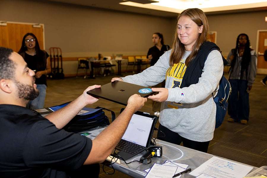 An E2D representative hands a new laptop to a first-year App State student during the Aug. 27 distribution event in Plemmons Student Union. Photo by Kyla Willoughby
