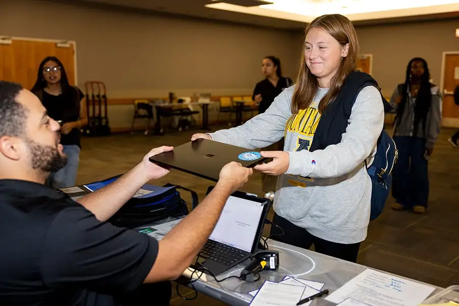An E2D representative hands a new laptop to a first-year App State student during the Aug. 27 distribution event in Plemmons Student Union. Photo by Kyla Willoughby