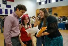 Ashe County GEAR UP Coordinator Hope Gambill reviews resumes with students at a career fair at Ashe County High School