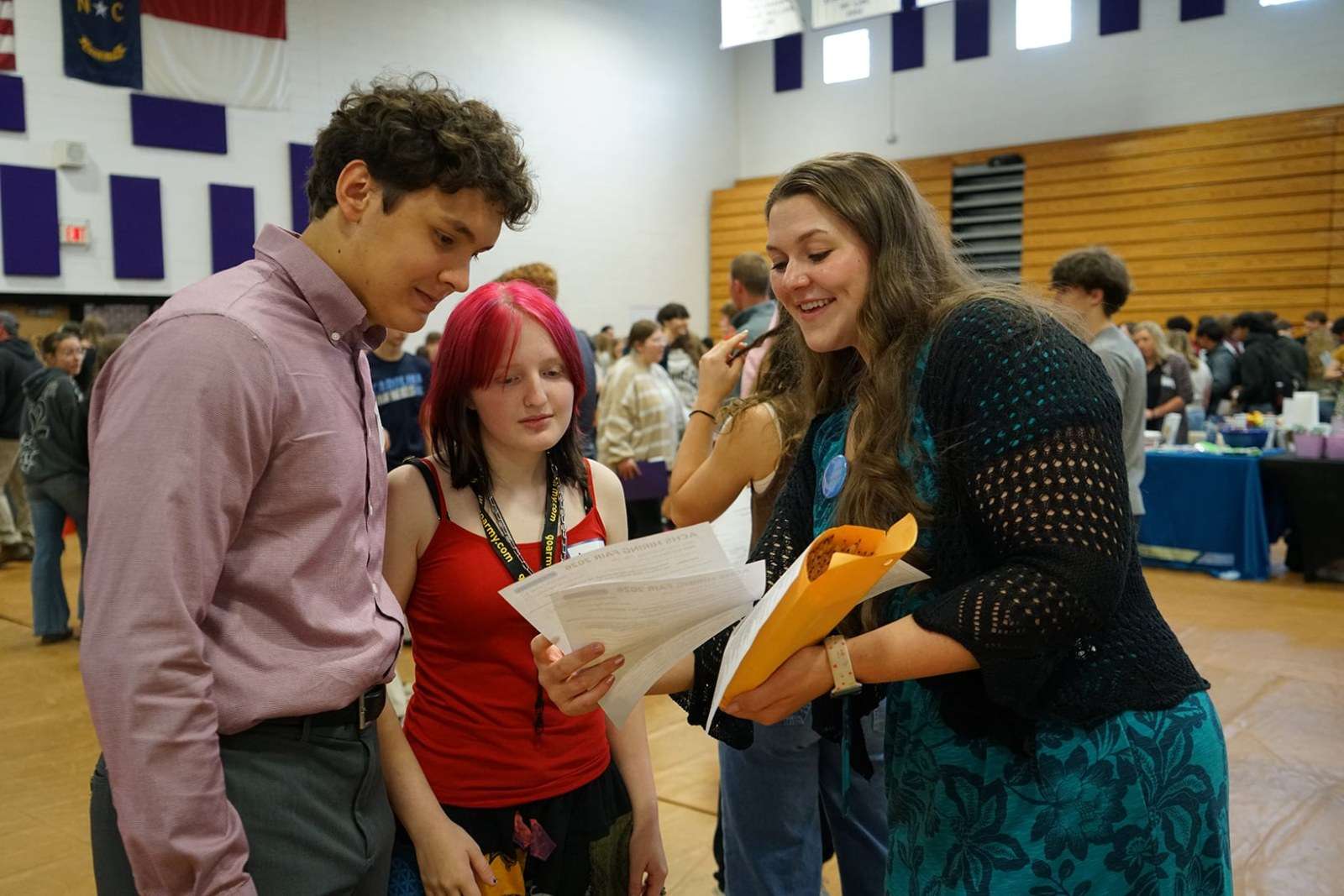Ashe County GEAR UP Coordinator Hope Gambill reviews resumes with students at a career fair at Ashe County High School