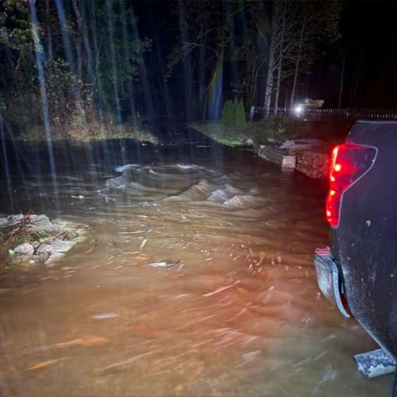 High water covering a roadway at night
